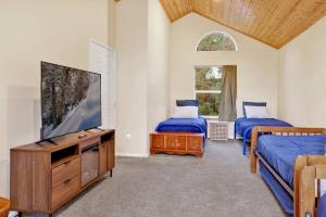 Un dormitorio con dos camas y un televisor de pantalla plana. en Mount Berkley Big Bear~ Walk to Village~ Games~, en Big Bear Lake