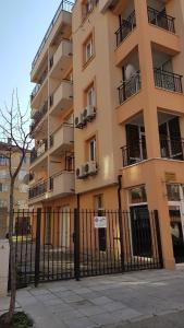 a tall building with a fence in front of it at Zefira Apartments in Pomorie