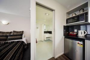 een kleine kamer met een bed en een keuken bij Willowbank Motel in Kaikoura