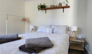 Un dormitorio con una cama grande con almohadas. en Seaside Aura, en Victor Harbor