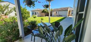 um pátio com uma mesa e cadeiras num alpendre em Seaside Aura em Victor Harbor