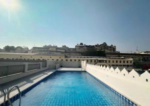 a swimming pool on the roof of a building at Manuscript - Jhilwara Haveli in Udaipur