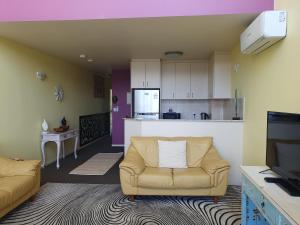 een woonkamer met een bank en een keuken bij Casablanca Penthouse Loft - Landmark 518 in Nelson Bay