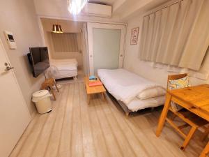 a small room with a bed and a table at 歌舞伎町/新宿站徒歩可#东新宿站徒歩3分#现代简约温馨公寓#最多3人 in Tokyo