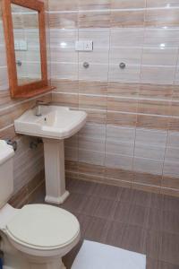 La salle de bains est pourvue de toilettes, d'un lavabo et d'un miroir. dans l'établissement Rupa Villa, à Beruwala