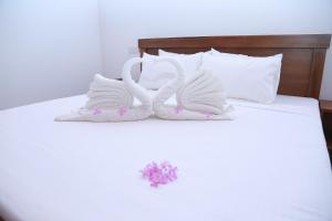 two swans shaped towels sitting on top of a bed at Rupa Villa in Beruwala