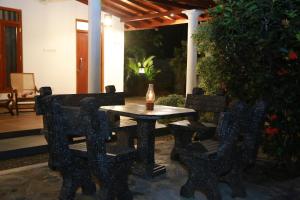 a table and chairs with a candle on a patio at Rupa Villa in Beruwala