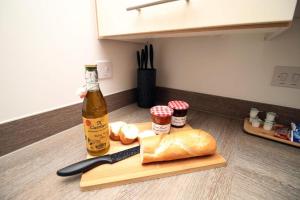 a bottle of beer and a loaf of bread on a cutting board at Free Wifi | Parking Access | 3BR in Rogerstone