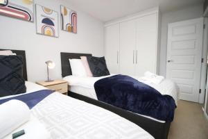 1 dormitorio con 2 camas y puerta en Free Wifi | Parking Access | 3BR, en Rogerstone