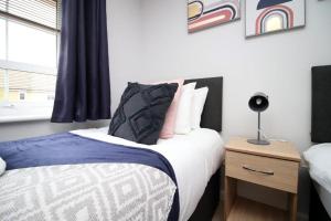 a bedroom with a bed and a nightstand with a bed sidx sidx at Free Wifi | Parking Access | 3BR in Rogerstone