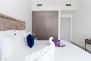 a bedroom with a large white bed with blue pillows at Dream Inn Apartments - Forte - The Opera District in Dubai