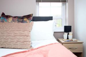 a bedroom with a bed and a window at Free Wifi | Parking Access | 3BR in Rogerstone