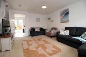 a living room with a couch and a tv and a table at Free Wifi | Parking Access | 3BR in Rogerstone