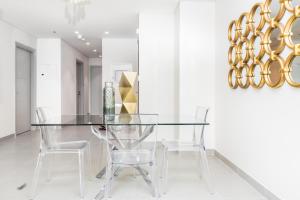 Dream Inn Apartments - Forte - The Opera District في دبي: غرفة طعام مع طاولة وكراسي زجاجية