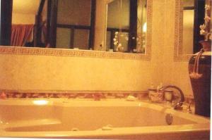 uma banheira na casa de banho com um espelho em Casa equipada 3 niveles em Tlaxcala de Xicohténcatl