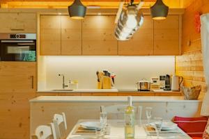 a kitchen with wooden cabinets and a table at Chalet Soleada - Happy Rentals 