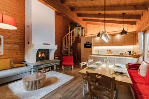 uma sala de estar com uma mesa e uma lareira em Chalet Soleada - Happy Rentals 