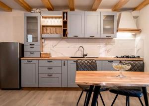 a kitchen with white cabinets and a wooden table at Holiday home in Vidovici - Insel Cres 43064 in Vidović