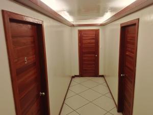 a hallway with two doors and a tiled floor at #1 Green Room Inn Siargao in General Luna