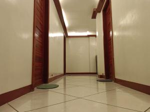 an empty hallway with two doors and a tile floor at #1 Green Room Inn Siargao in General Luna