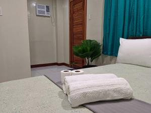 a bedroom with a bed with two towels on it at #1 Green Room Inn Siargao in General Luna