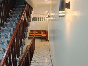 a hallway with stairs with a couch in the distance at #1 Green Room Inn Siargao in General Luna