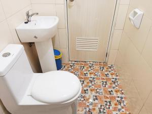 a bathroom with a toilet and a sink and a shower at #1 Green Room Inn Siargao in General Luna