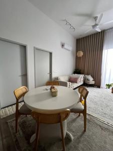a living room with a table and chairs and a couch at Aisha’s staycation big patio Putrajaya in Putrajaya