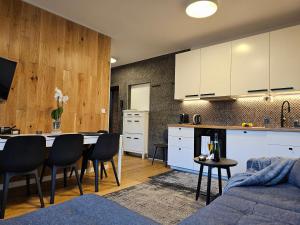 een keuken en een woonkamer met een tafel en stoelen bij URBAN APARTMENTS Premium No 3 Chorzów Katowice, FREE PRIVATE PARKING in Chorzów
