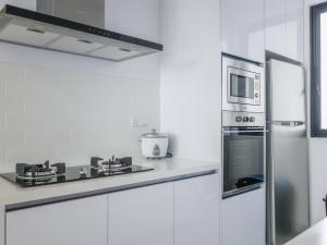 uma cozinha branca com um micro-ondas e um fogão em Beacon Executive Suites by S&F #InfinityPool #SkyGym em George Town