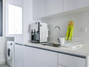 uma cozinha branca com um lavatório e um micro-ondas em Beacon Executive Suites by S&F #InfinityPool #SkyGym em George Town