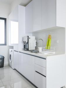 uma cozinha branca com um lavatório e uma máquina de lavar roupa em Beacon Executive Suites by S&F #InfinityPool #SkyGym em George Town