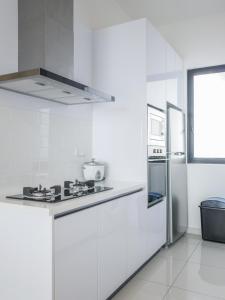 uma cozinha branca com um fogão e um frigorífico em Beacon Executive Suites by S&F #InfinityPool #SkyGym em George Town
