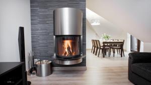 a fireplace in a living room with a dining room table at Rezydencja Sunny Hill in Karpacz