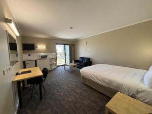 een hotelkamer met een bed en een bureau bij Geraldton Motor Inn in Geraldton