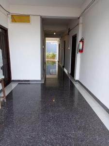 an empty hallway in a building with black flooring at Punjab Residency in Port Blair