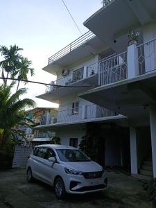 a white car parked in front of a building at Punjab Residency in Port Blair