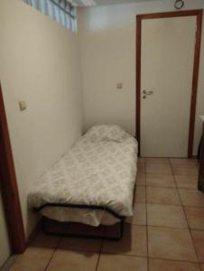 un piccolo letto in una stanza con porta di Gîte du Cheval Blanc a Sainte-Ode