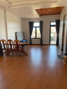 an empty living room with a table and chairs at HUNA House in Da Lat