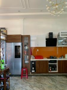 a kitchen with a stainless steel refrigerator and a table at HUNA House in Da Lat