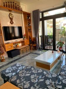 a living room with a tv and a coffee table at HUNA House in Da Lat