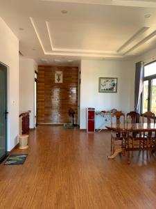 an empty living room with a table and chairs at HUNA House in Da Lat
