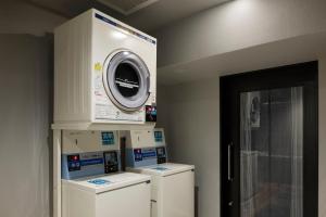 a laundry room with three washes and a dryer at the b osaka-shinsekai in Osaka