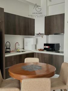 a kitchen with a wooden table and some chairs at #Free Netflix 1BR Troika Residensi Kota Bharu By AGhome in Kota Bharu
