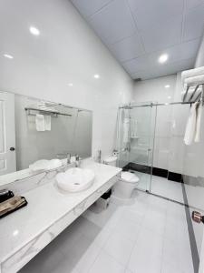 a bathroom with two sinks and a shower and a toilet at Paris Hotel Châu Đốc in Chau Doc