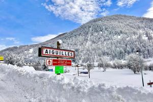 una señal en la nieve frente a una montaña en CASA-Bruno family chalet Queyras 7p, en Aiguilles