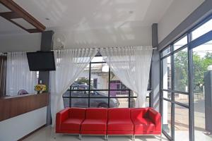 a red couch in a room with a window at Super OYO Capital O 92096 Kuala Ulee Lheue Residence Syariah in Banda Aceh