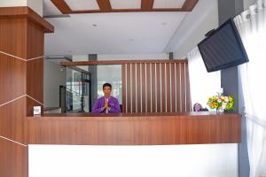 un hombre de pie en un podio con un micrófono en Super OYO Capital O 92096 Kuala Ulee Lheue Residence Syariah en Banda Aceh
