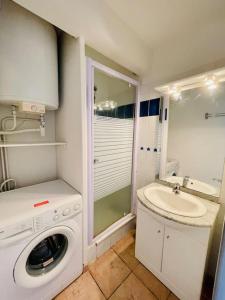 uma casa de banho com uma máquina de lavar roupa e um lavatório em Maison au bord de l'eau em Gruissan
