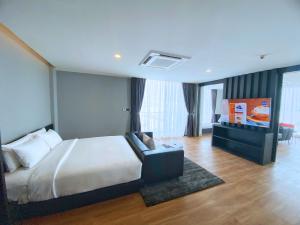 ein Schlafzimmer mit einem Bett und einem Sofa in einem Zimmer in der Unterkunft BB hotel Savannakhet in Savannakhet
